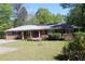 Charming brick home featuring a well-maintained lawn, inviting curb appeal, and vibrant flowering bushes at 1646 Hurt Sw Rd, Marietta, GA 30008