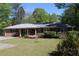 Charming brick home featuring a well-maintained lawn, inviting curb appeal, and vibrant flowering bushes at 1646 Hurt Sw Rd, Marietta, GA 30008