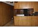 Functional kitchen area featuring wood paneled walls, basic appliances, and a counter area at 1646 Hurt Sw Rd, Marietta, GA 30008