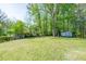 Large, grassy backyard with mature trees and storage shed at 3719 Paul St, Douglasville, GA 30135