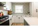 A stunning kitchen featuring white cabinets, countertops, and a geometric tile backsplash at 3719 Paul St, Douglasville, GA 30135