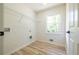 Well-lit laundry room with utility connections, wire shelving, and wood-look floor at 3719 Paul St, Douglasville, GA 30135
