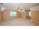 Spacious bedroom with neutral walls, carpet, ceiling fan, and multiple windows at 4503 Rivercliff Sw Dr, Lilburn, GA 30047