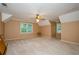 Spacious bedroom with neutral carpeting, a ceiling fan, two windows, and vaulted ceilings at 4503 Rivercliff Sw Dr, Lilburn, GA 30047