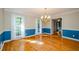 Bright dining room with hardwood floors, large windows, wainscoting and a chandelier at 4503 Rivercliff Sw Dr, Lilburn, GA 30047