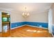 Dining room featuring hardwood floors, chandelier, and wainscoting at 4503 Rivercliff Sw Dr, Lilburn, GA 30047
