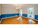 Elegant dining room featuring hardwood floors, a chandelier, wainscoting, and natural light from large windows at 4503 Rivercliff Sw Dr, Lilburn, GA 30047