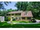 Beautiful yellow two-story home featuring dark shutters, an inviting walkway, and lush landscaping at 4503 Rivercliff Sw Dr, Lilburn, GA 30047