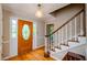 Bright foyer featuring hardwood floors, a decorative front door, and a staircase leading upstairs at 4503 Rivercliff Sw Dr, Lilburn, GA 30047