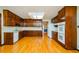 Traditional kitchen features wooden cabinets, hardwood floors, and white appliances at 4503 Rivercliff Sw Dr, Lilburn, GA 30047