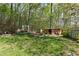 Backyard with wooden storage shed, swing, mature trees, and lush green grass at 5539 Hurstcliffe Nw Dr, Kennesaw, GA 30152
