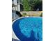 Above-ground pool in a sunny backyard, offering a refreshing escape with a view of the home's exterior and lush greenery at 5539 Hurstcliffe Nw Dr, Kennesaw, GA 30152