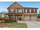 Charming brick home with a covered porch, two-car garage, and manicured front yard landscaping at 811 Holly Mist Ct, Loganville, GA 30052