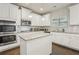 Bright kitchen featuring white cabinets, stainless appliances, granite counters, and an island at 811 Holly Mist Ct, Loganville, GA 30052