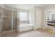 Elegant bathroom features a glass enclosed shower and a separate soaking tub at 811 Holly Mist Ct, Loganville, GA 30052