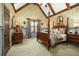 Spacious bedroom featuring a four-poster bed, patterned wallpaper, wood accents, and neutral carpet flooring at 2740 Drayton Hall Dr, Buford, GA 30519