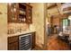 Butler's pantry featuring a wine fridge and dark wood cabinets with glass doors at 2740 Drayton Hall Dr, Buford, GA 30519