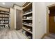 Custom walk-in closet with built in shelving, shoe storage and wooden floors at 2740 Drayton Hall Dr, Buford, GA 30519