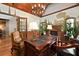 Beautiful office space boasts wood-beamed ceilings, a grand desk, and an inviting fireplace at 2740 Drayton Hall Dr, Buford, GA 30519