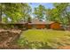 Green backyard features a large grassy area, a wood fence and an exterior view of home at 3444 Wood Acres Blvd, Duluth, GA 30096