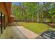 Green backyard features a large grassy area, mature trees and a wood fence at 3444 Wood Acres Blvd, Duluth, GA 30096