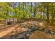 Backyard features stone pavers leading to a hot tub, hammock, and outdoor seating area at 3444 Wood Acres Blvd, Duluth, GA 30096