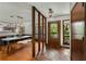 Dining room with stone floors, modern light fixture, and decorative leaded glass door at 3444 Wood Acres Blvd, Duluth, GA 30096