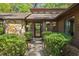 Home's entrance with a black screen door and manicured landscaping surrounding it at 3444 Wood Acres Blvd, Duluth, GA 30096