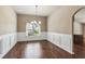 Dining area with wood floors, wainscoting, natural light from window, and view to the kitchen at 4580 Orchard Ridge Ct, Cumming, GA 30028