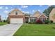 Charming single-Gathering home featuring a brick facade, well-manicured lawn, and an attached two-car garage at 4580 Orchard Ridge Ct, Cumming, GA 30028