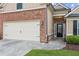 Close-up of a home's exterior featuring a two-car garage, brick facade, and inviting front entrance at 4580 Orchard Ridge Ct, Cumming, GA 30028