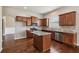 Well-lit kitchen features stainless steel appliances, granite countertops, and dark wood cabinets and floors at 4580 Orchard Ridge Ct, Cumming, GA 30028
