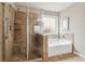 Shower and soaking tub featuring tile surround and tile floors in the main bath at 4580 Orchard Ridge Ct, Cumming, GA 30028