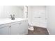 Bathroom features a white vanity and shower over dark wood look vinyl flooring at 56 Windom Dr, Carrollton, GA 30116