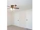 Bedroom features neutral walls and carpet with a ceiling fan and doors at 56 Windom Dr, Carrollton, GA 30116