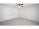Bedroom features neutral walls and carpet with a ceiling fan and multiple doors at 56 Windom Dr, Carrollton, GA 30116