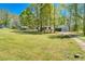 Exterior view of the house with well-maintained lawn and outbuildings, perfect for outdoor activities and storage at 56 Windom Dr, Carrollton, GA 30116