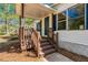 Inviting front porch with wood railing and steps leading to the home's entrance at 56 Windom Dr, Carrollton, GA 30116