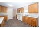 Functional kitchen featuring wood cabinets, white appliances, and neutral countertops at 56 Windom Dr, Carrollton, GA 30116