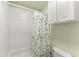 Bright bathroom with a shower-tub combination and green leafy shower curtain at 602 Redbud Ter, Canton, GA 30115
