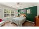 Cozy bedroom featuring a large window, ceiling fan, and green accent wall at 602 Redbud Ter, Canton, GA 30115