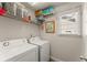 Convenient laundry room with modern white washer and dryer, plus shelving at 602 Redbud Ter, Canton, GA 30115