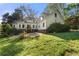 Backyard with a lush green lawn and mature trees surrounding the home at 6048 Kings Mountain Way, Tucker, GA 30087