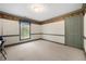Empty bedroom with neutral carpet, green trim, and a large window overlooking the backyard at 6048 Kings Mountain Way, Tucker, GA 30087