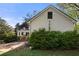 Exterior of home featuring white siding and a well-manicured lawn with mature trees and shrubbery at 6048 Kings Mountain Way, Tucker, GA 30087