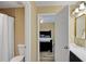 Bright bathroom with toilet, shower with white curtain, leading to the bedroom at 6884 Robinson St, Lithonia, GA 30058