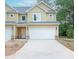 Charming two-story townhome with a spacious two-car garage and well-manicured lawn at 6884 Robinson St, Lithonia, GA 30058