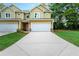 Charming new construction townhouse with a two-car garage, manicured lawn, and inviting curb appeal at 6884 Robinson St, Lithonia, GA 30058