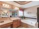 A relaxing bathroom features a large tub and vanity with a large mirror and stylish lighting at 725 Martin Field Dr, Lawrenceville, GA 30045