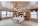 Primary bedroom with tray ceiling, fan, carpet, and two windows at 725 Martin Field Dr, Lawrenceville, GA 30045